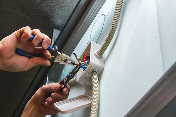 A person is working on a light switch.